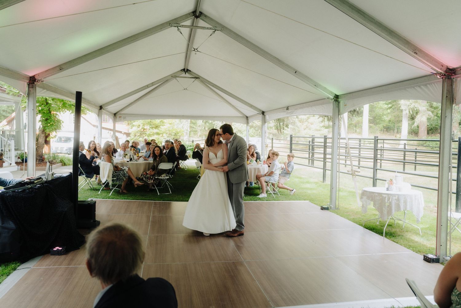 Large white wedding reception tent with tables set up for outdoor celebration.