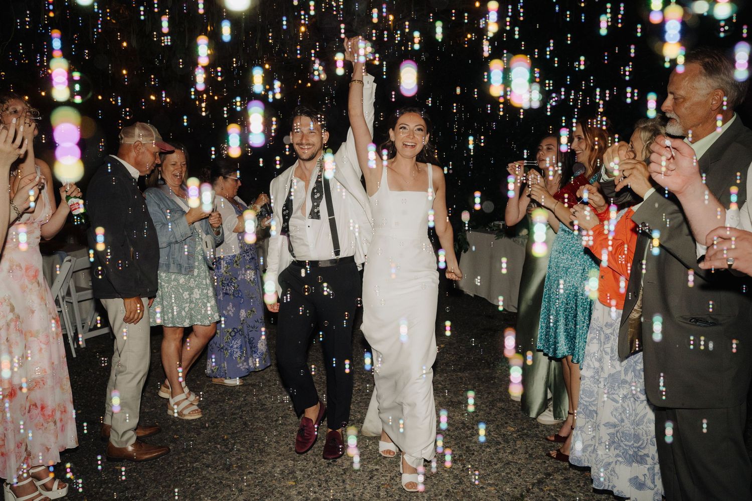 Wedding celebration at night with hanging lights creating a magical atmosphere.