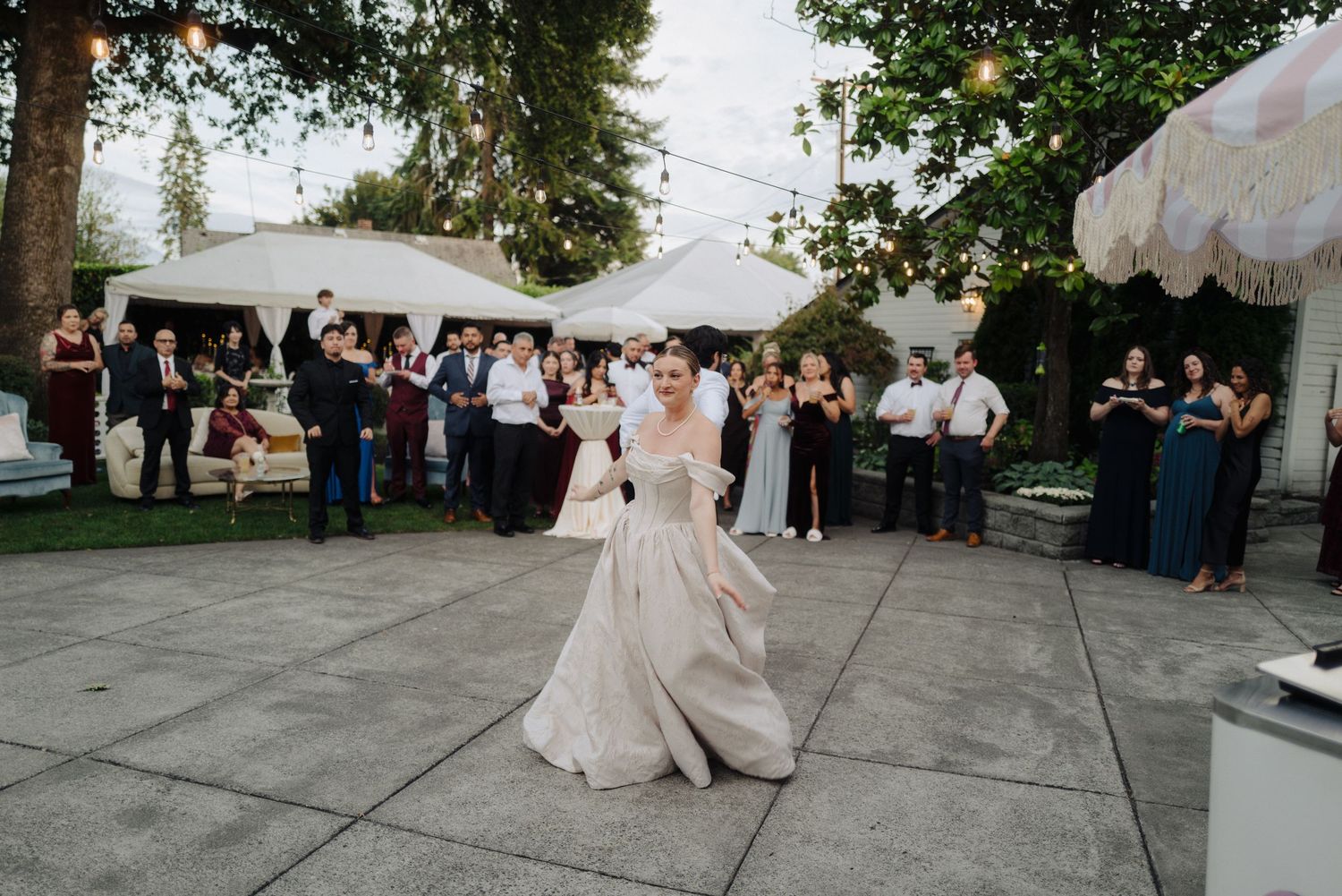 Elegant outdoor wedding reception setup with white tents and natural greenery overhead.