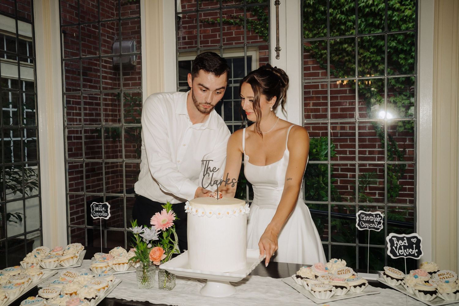 Wedding reception scene at a brick venue with large windows and ivy-covered walls.