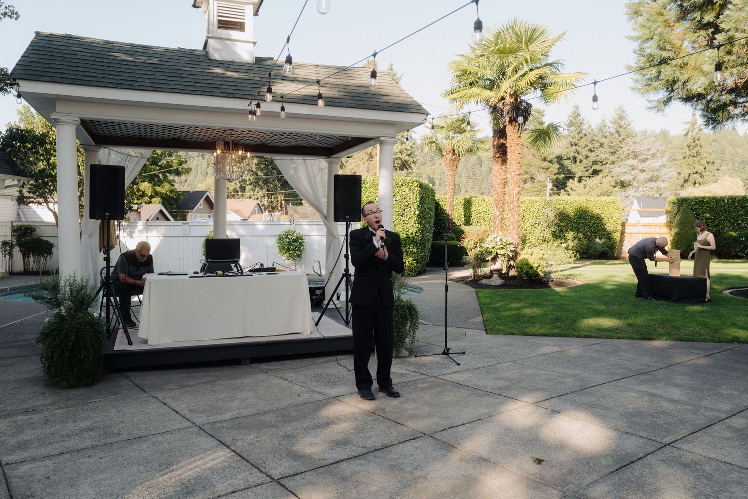 Wide angle shots of an outdoor wedding venue with string lights and reception setup.