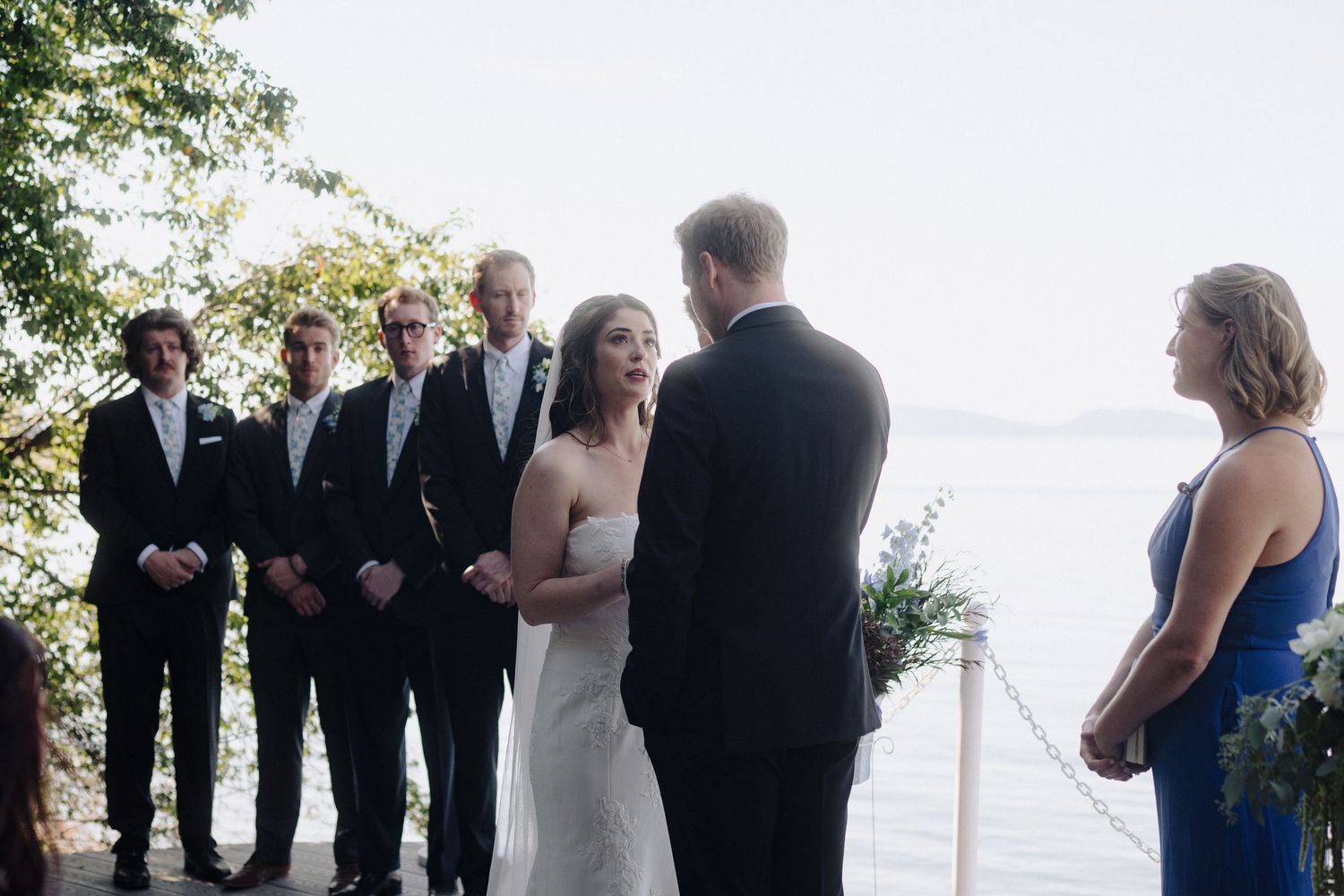 Intimate wedding ceremony taking place on a waterfront deck with ocean views.