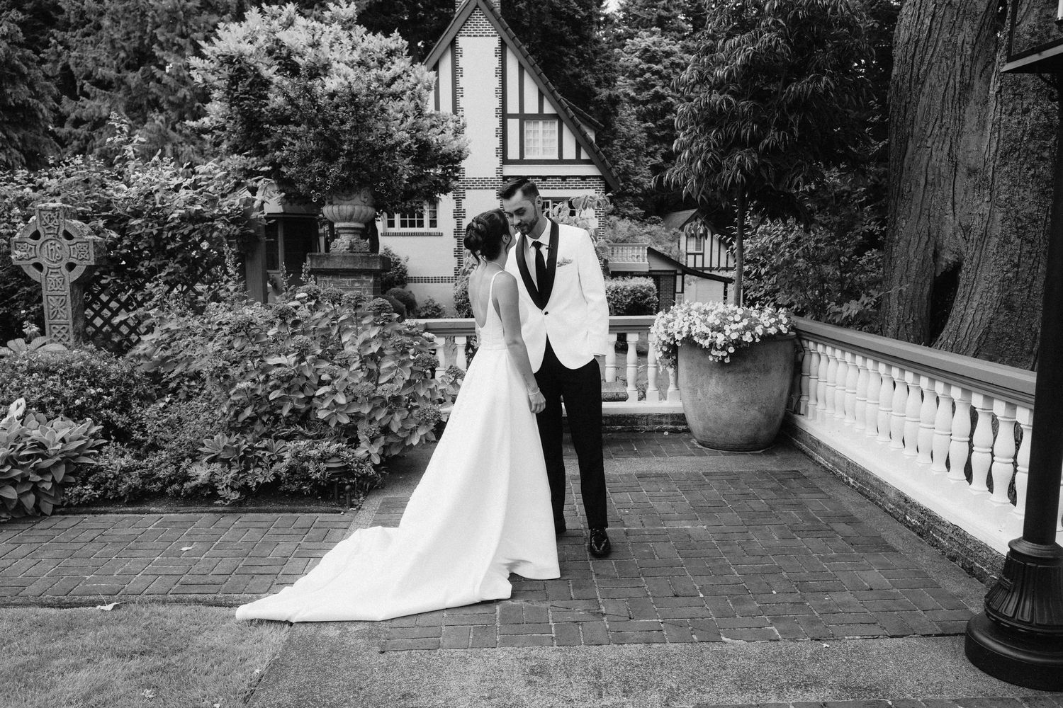 A bride and groom share romantic moments in a garden setting across multiple black and white wedding photographs.
