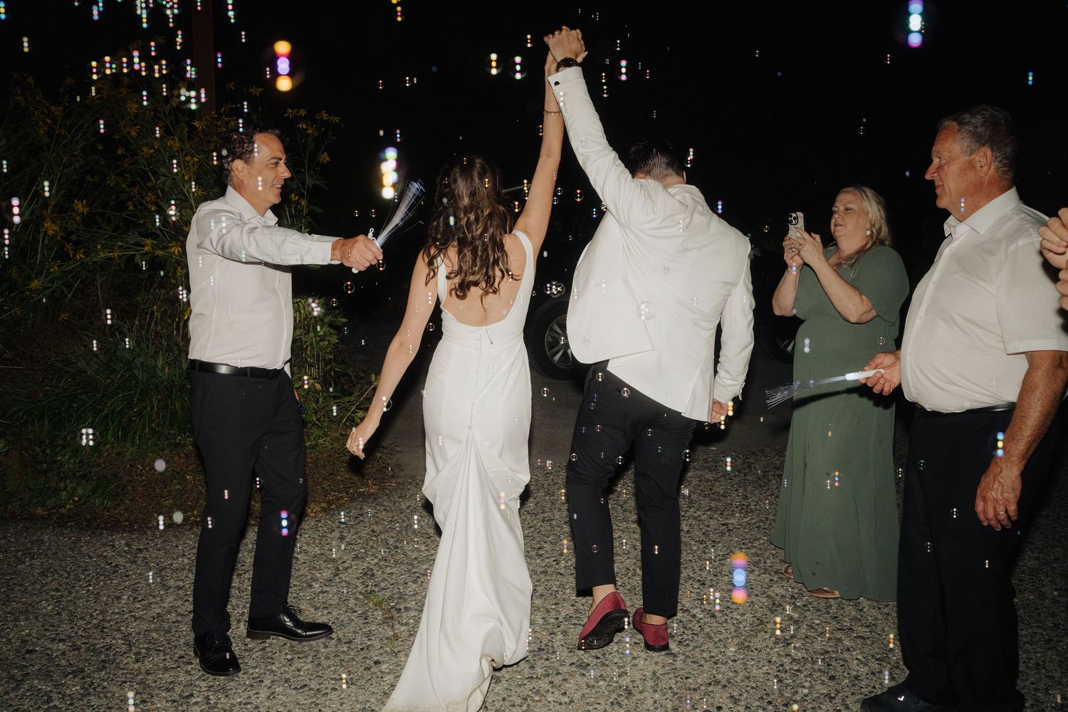 Wedding guests dancing in a joyful celebration under the night sky.