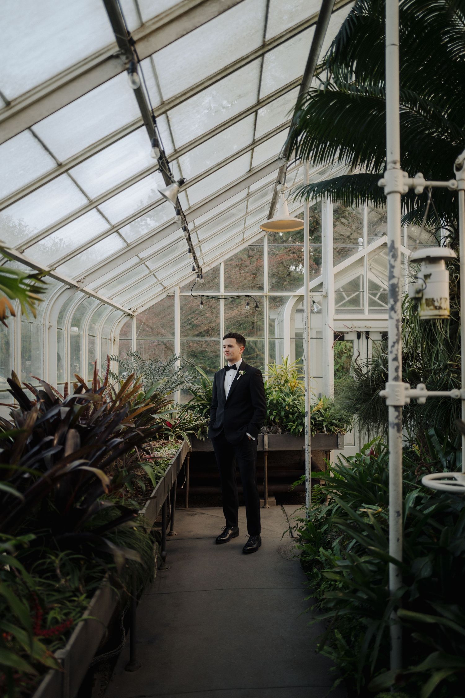 Elegant greenhouse interior with tropical plants and architecture creating a dramatic wedding venue backdrop.