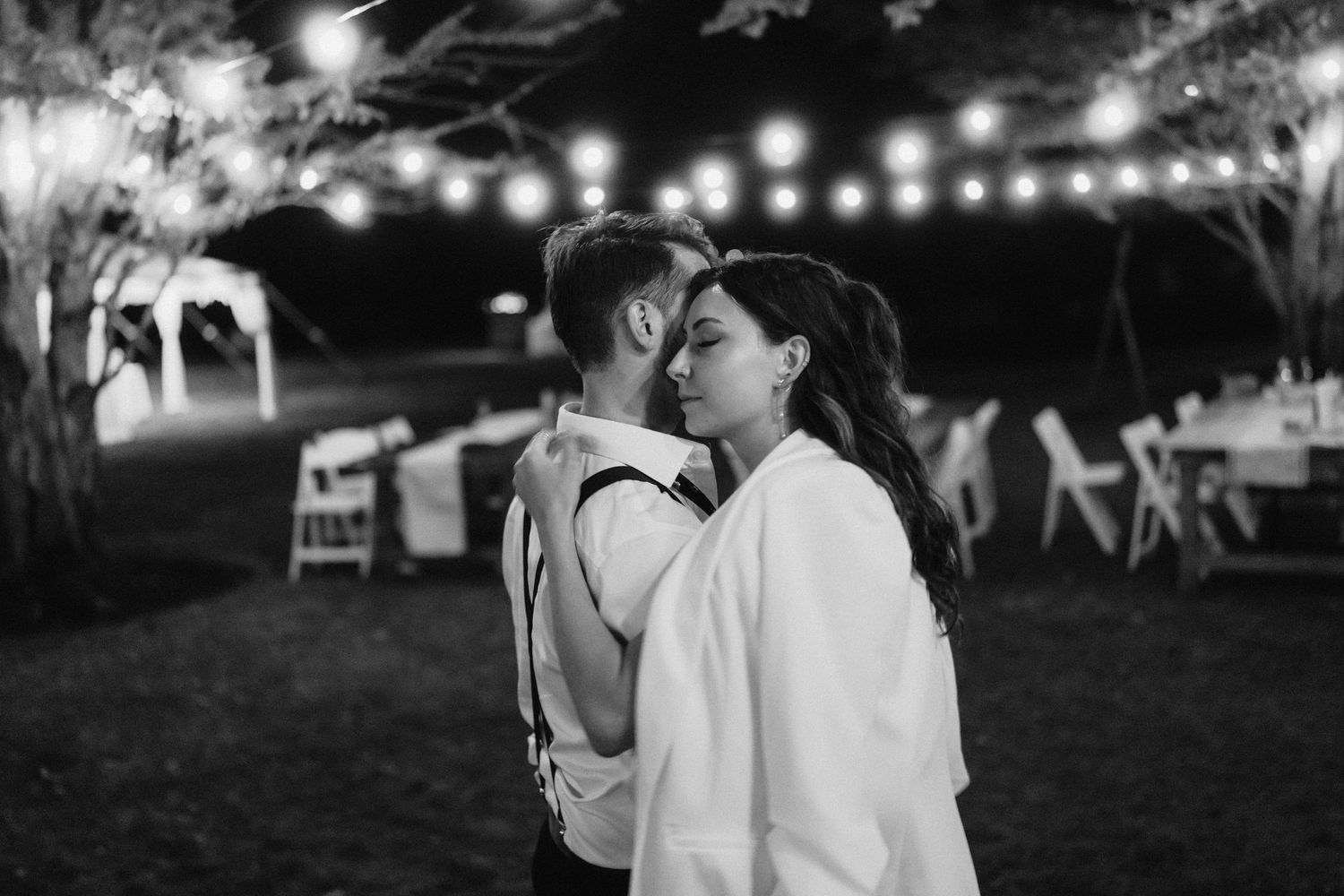 String lights illuminate an evening outdoor celebration creating a romantic ambiance.