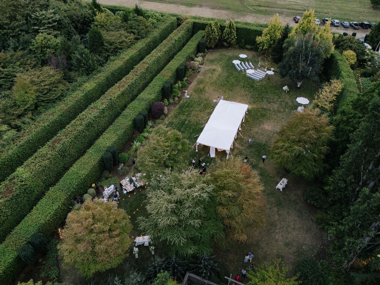 Aerial view of a garden wedding venue with manicured hedges and guest seating.
