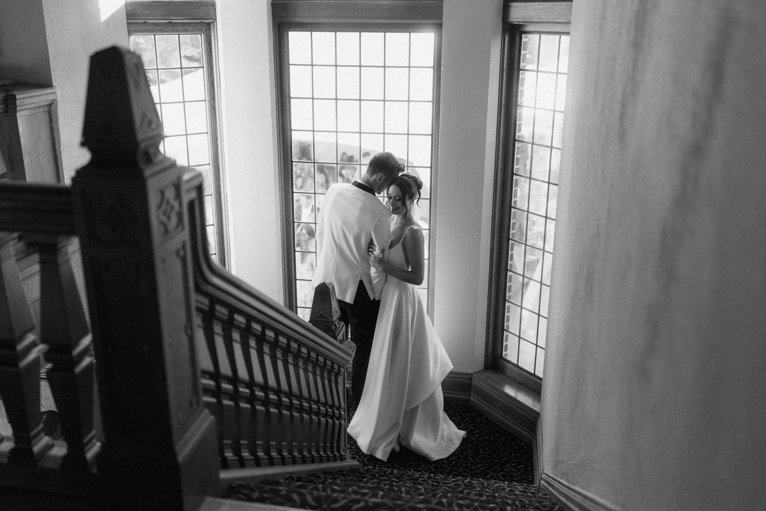Silhouetted figures in a grand interior space with dramatic window lighting.