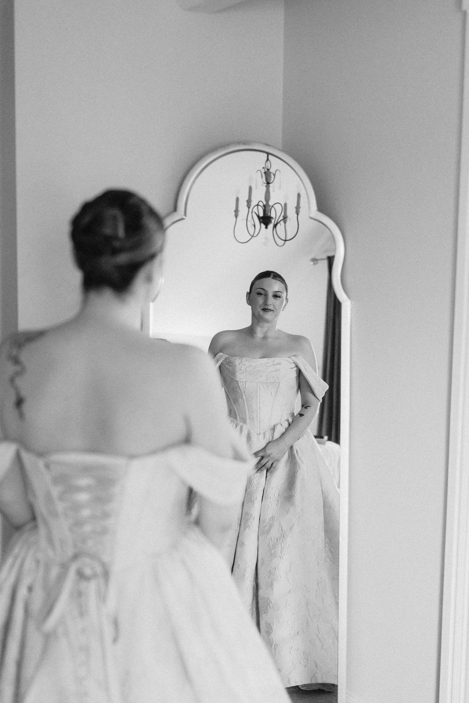 A sequence of black and white photos showing a wedding dress being fitted in a mirror.