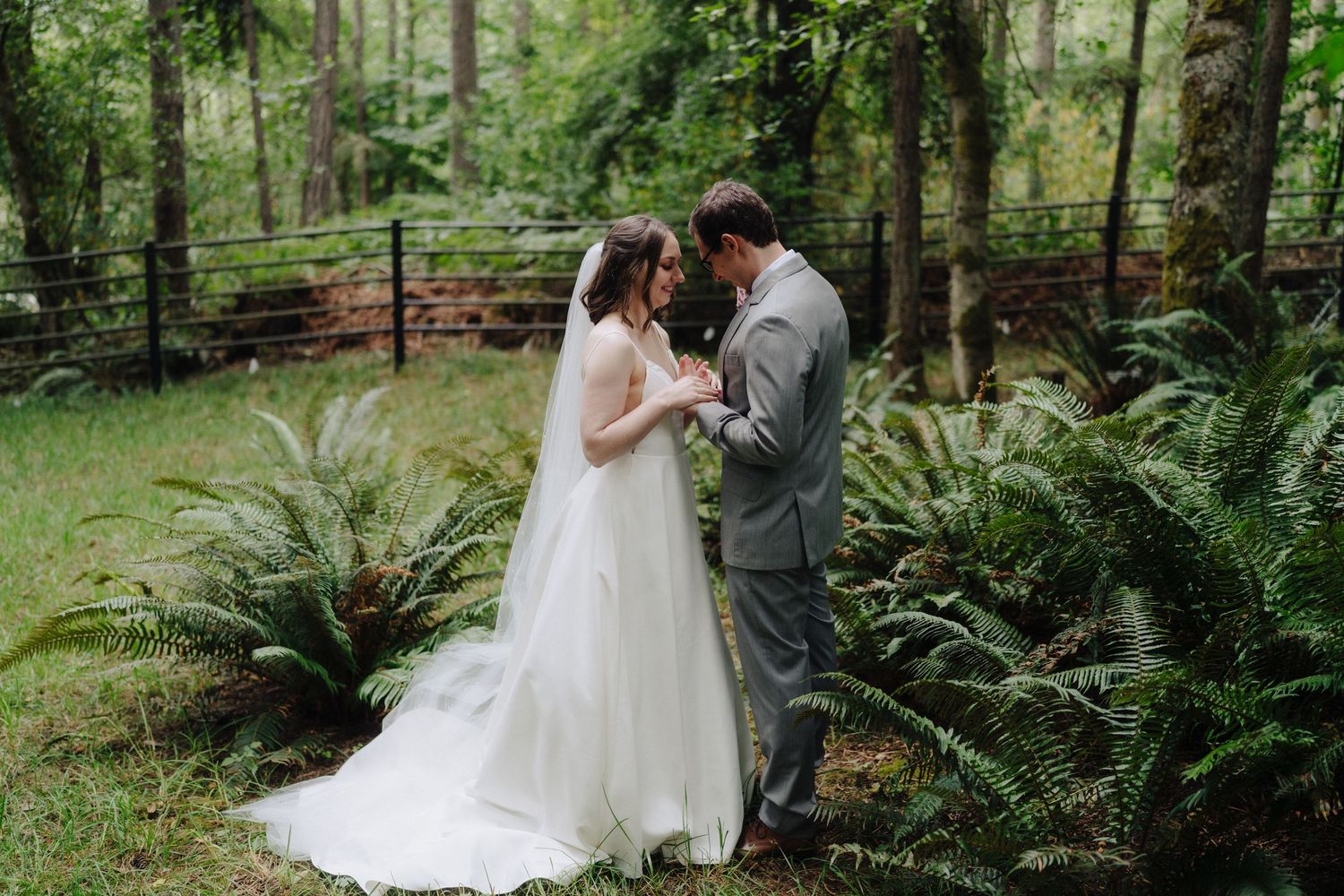 Romantic wedding portraits taken in a serene forest setting with abundant ferns.