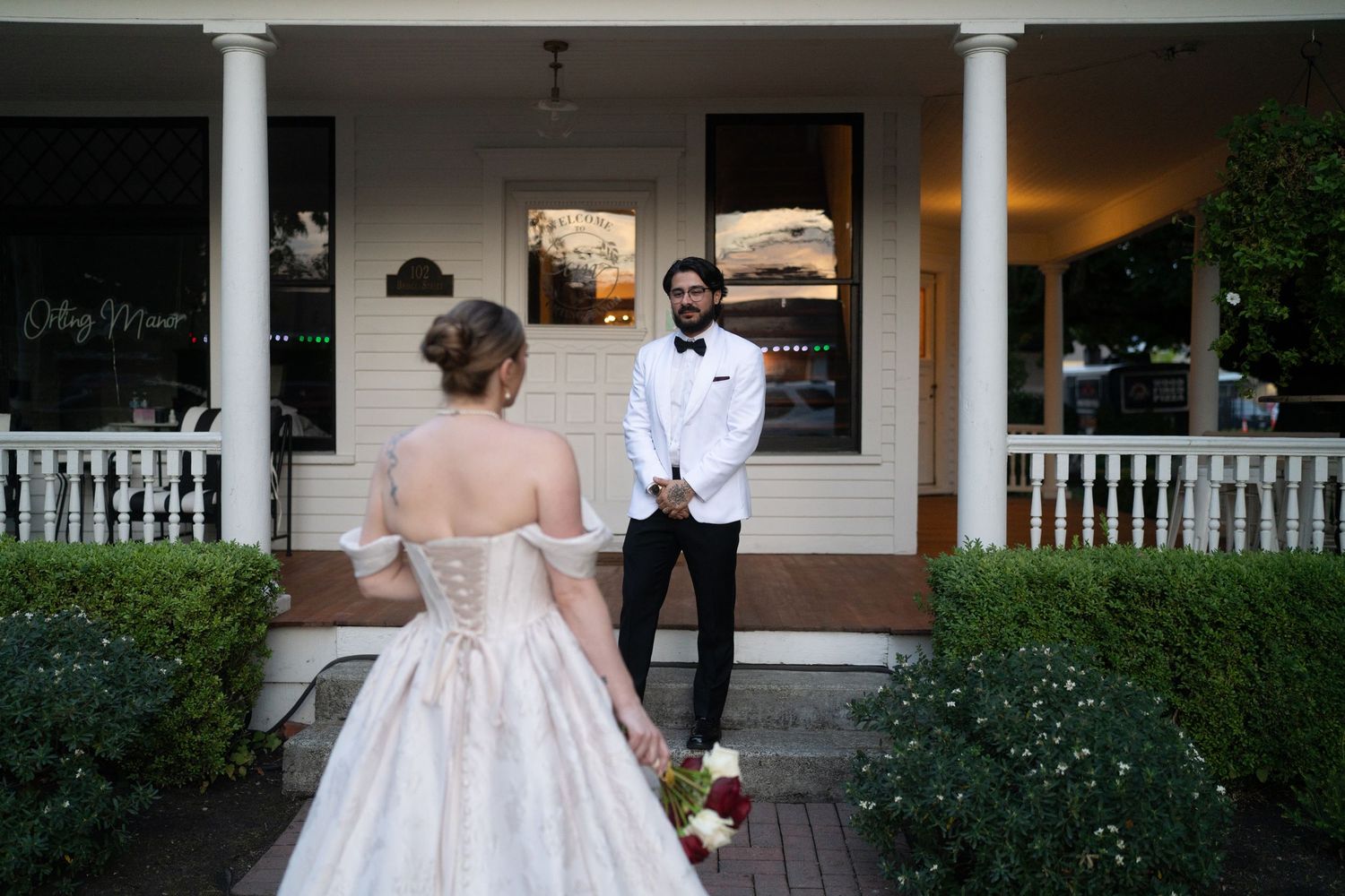 Elegant outdoor wedding venue with white columns and porch decorated for an evening celebration.