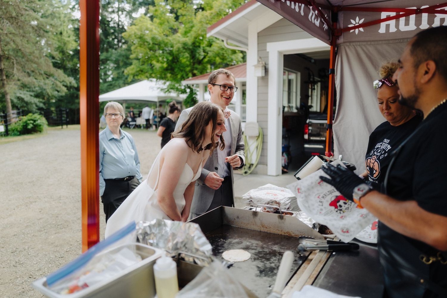 Guests ordering from a food truck at an outdoor wedding reception.