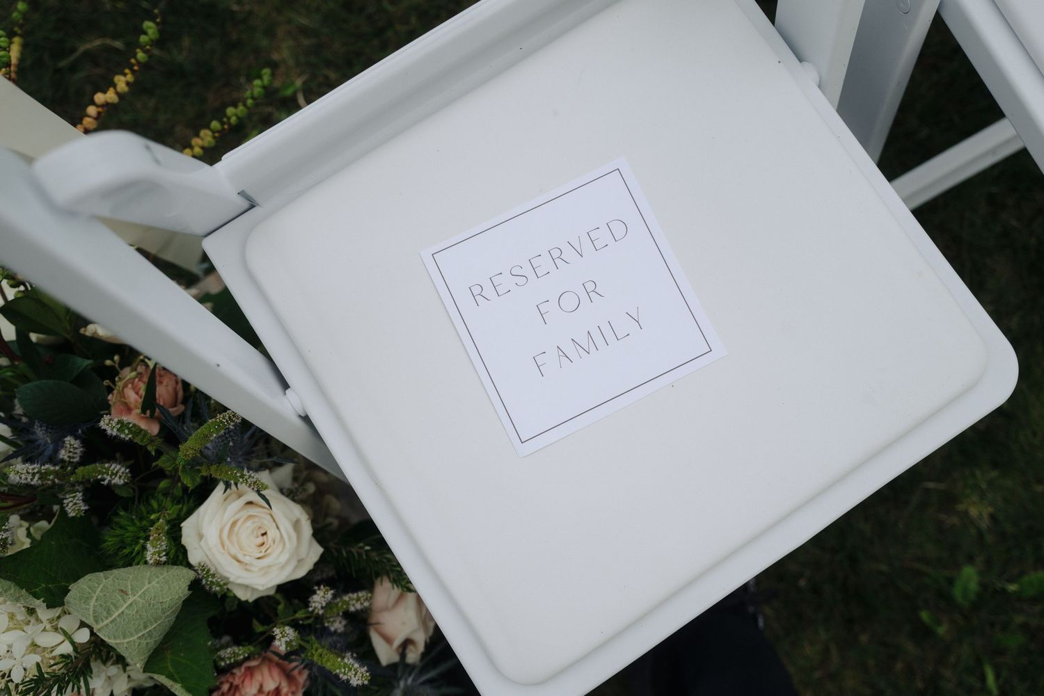 White wedding gift boxes arranged on a dark surface with elegant rose decorations.