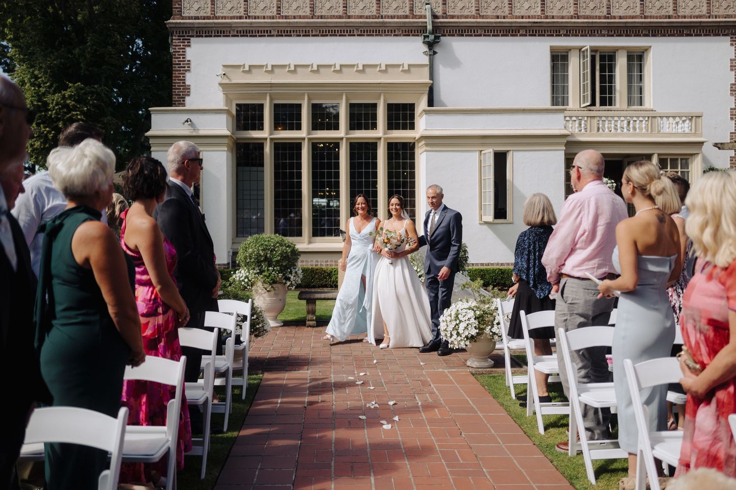 A sequence of wedding ceremony photos showing guests seated in white chairs on a garden terrace.