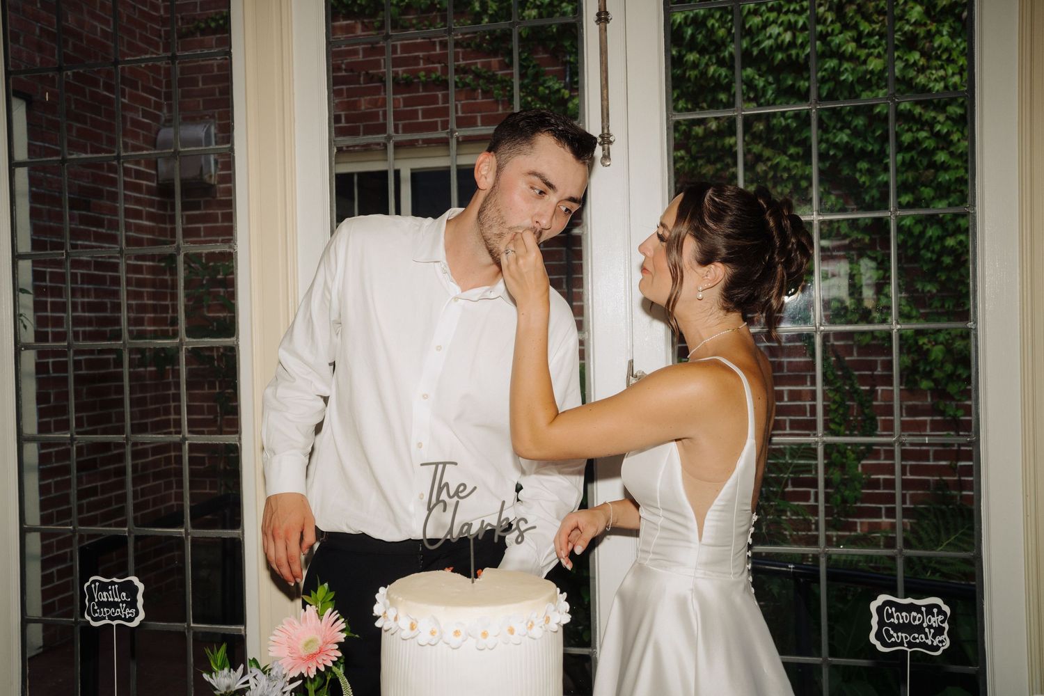 Intimate dance moment by window with brick and ivy backdrop.