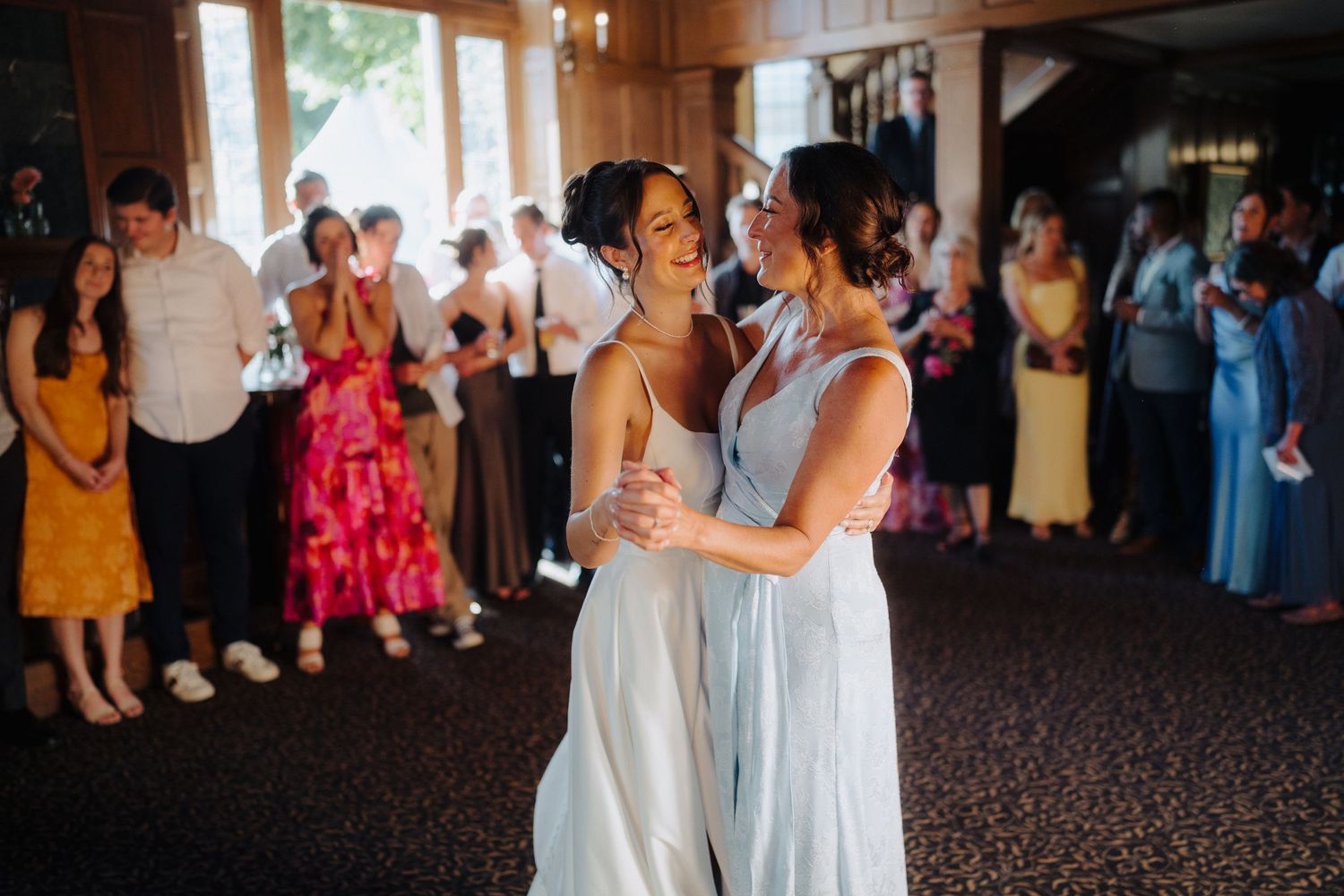 Wedding reception guests dancing and celebrating in an indoor venue.