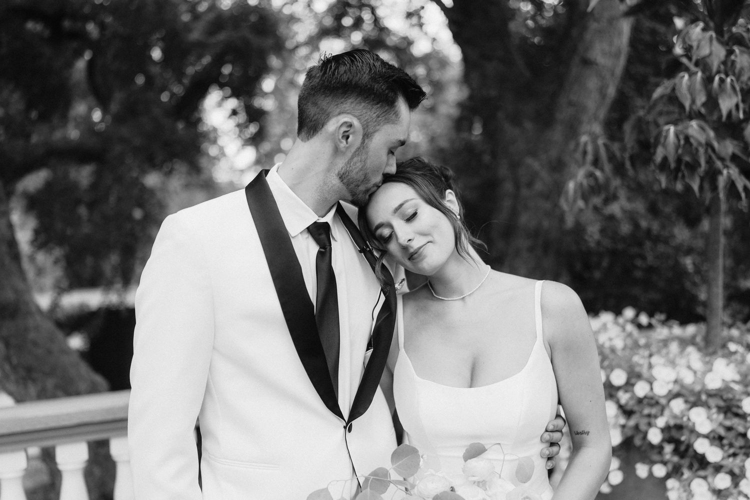 Romantic black and white wedding photos captured in an outdoor garden setting.