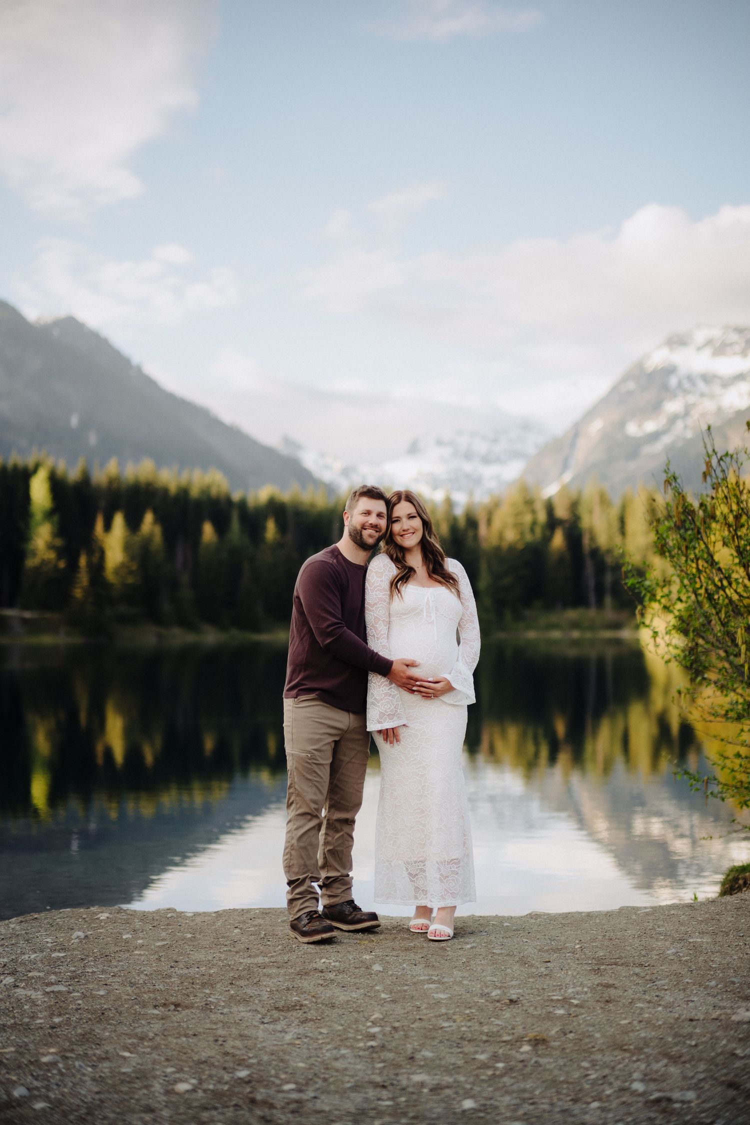 Romantic proposal scene by a mountain lake with snow-capped peaks in the background.