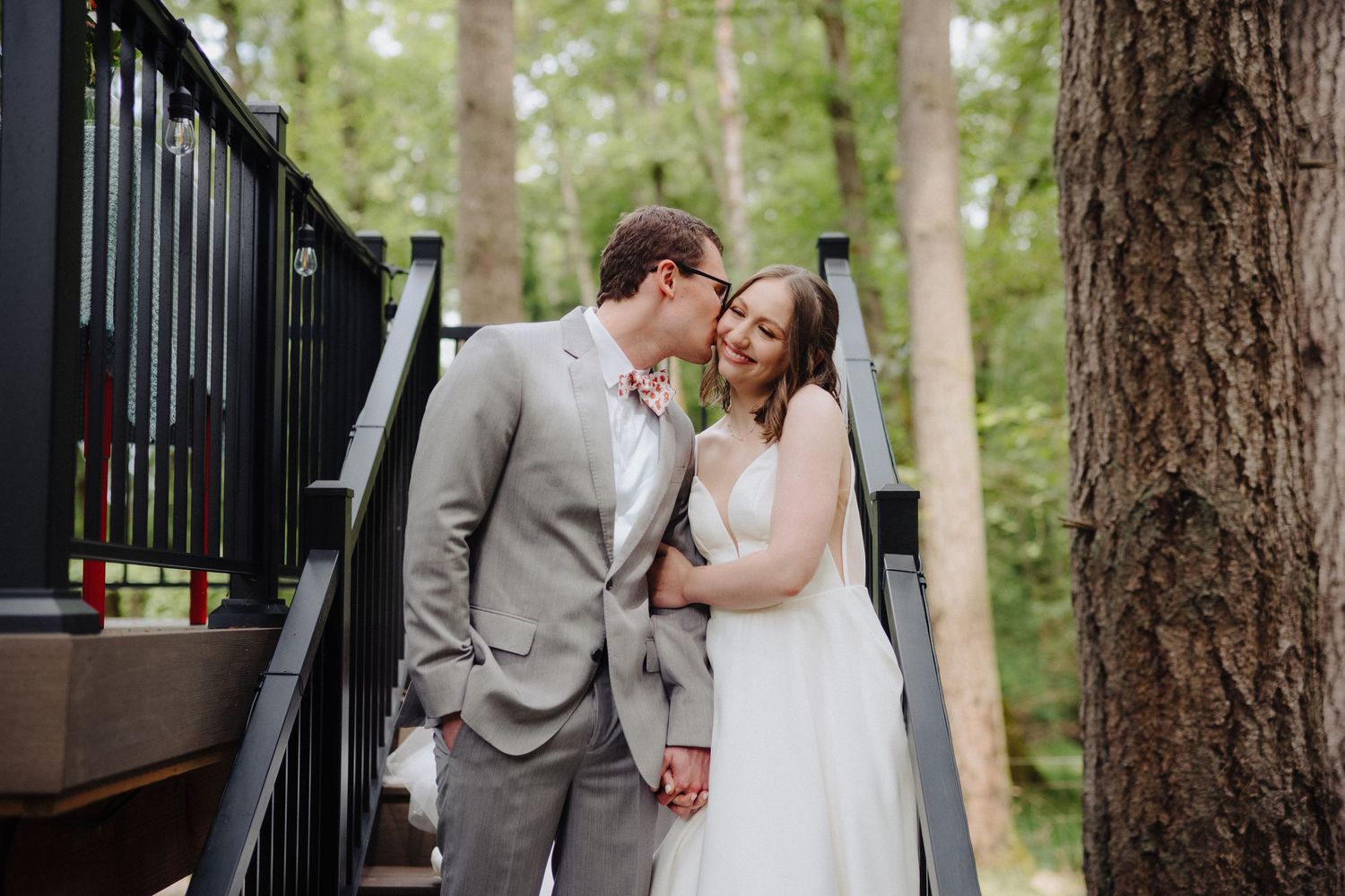 Intimate wedding moments captured on a rustic wooden deck surrounded by trees.