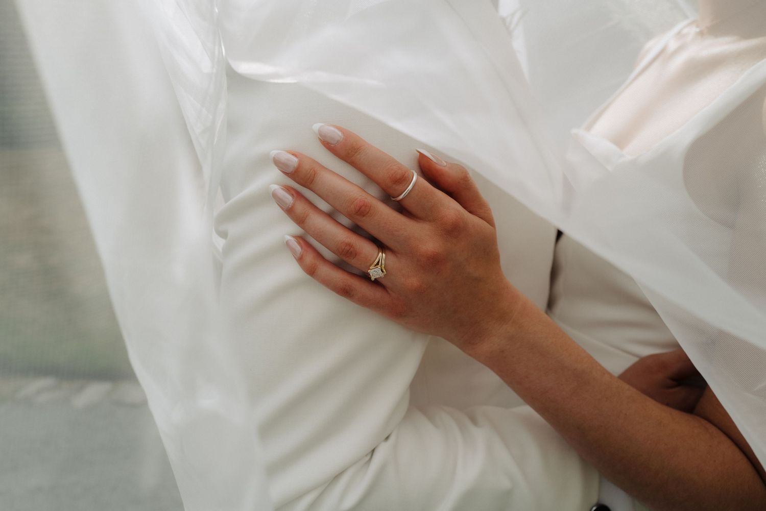 Close-up details of white wedding dress fabric and delicate lace textures.