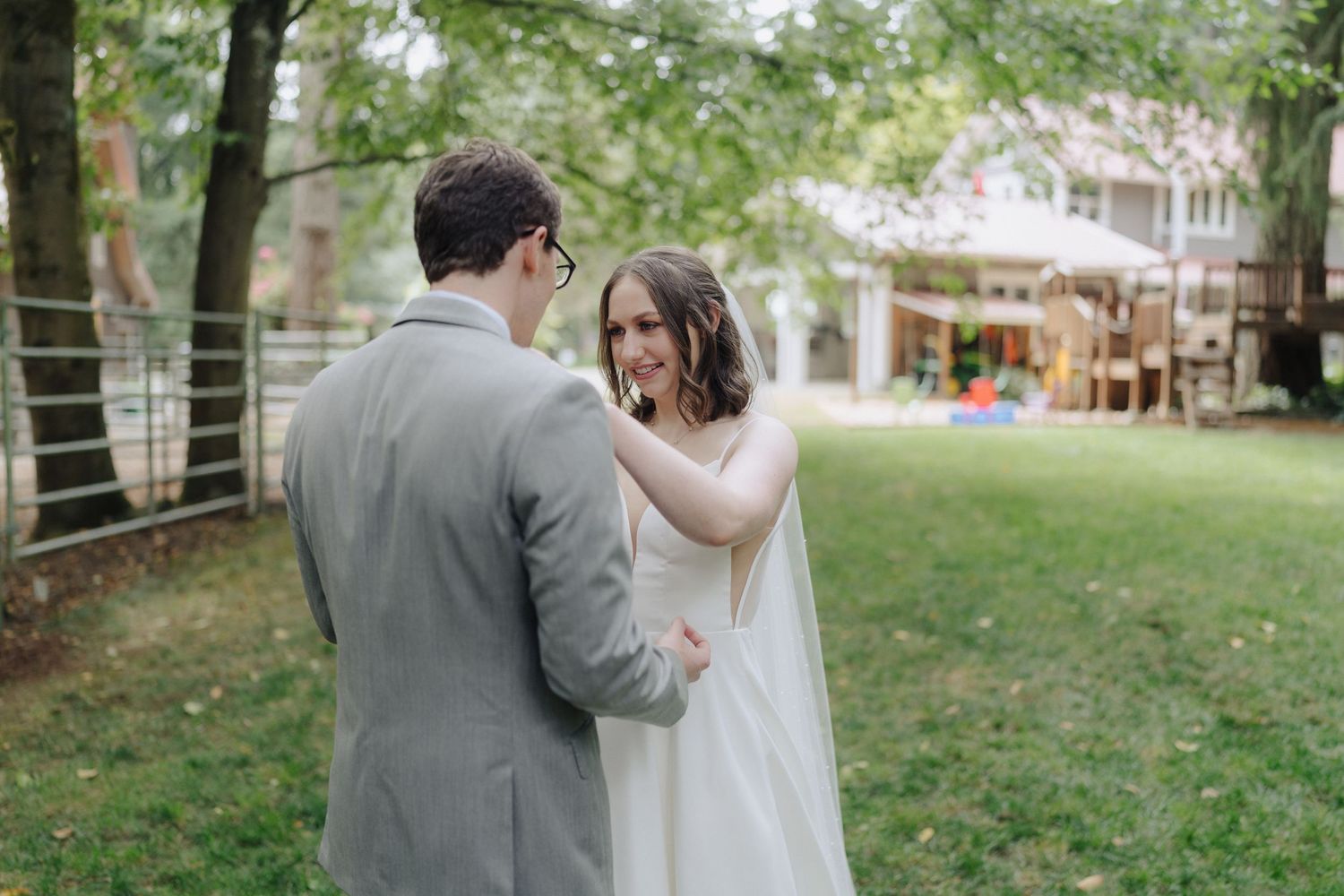 A romantic moment shared between newlyweds in a backyard garden setting.