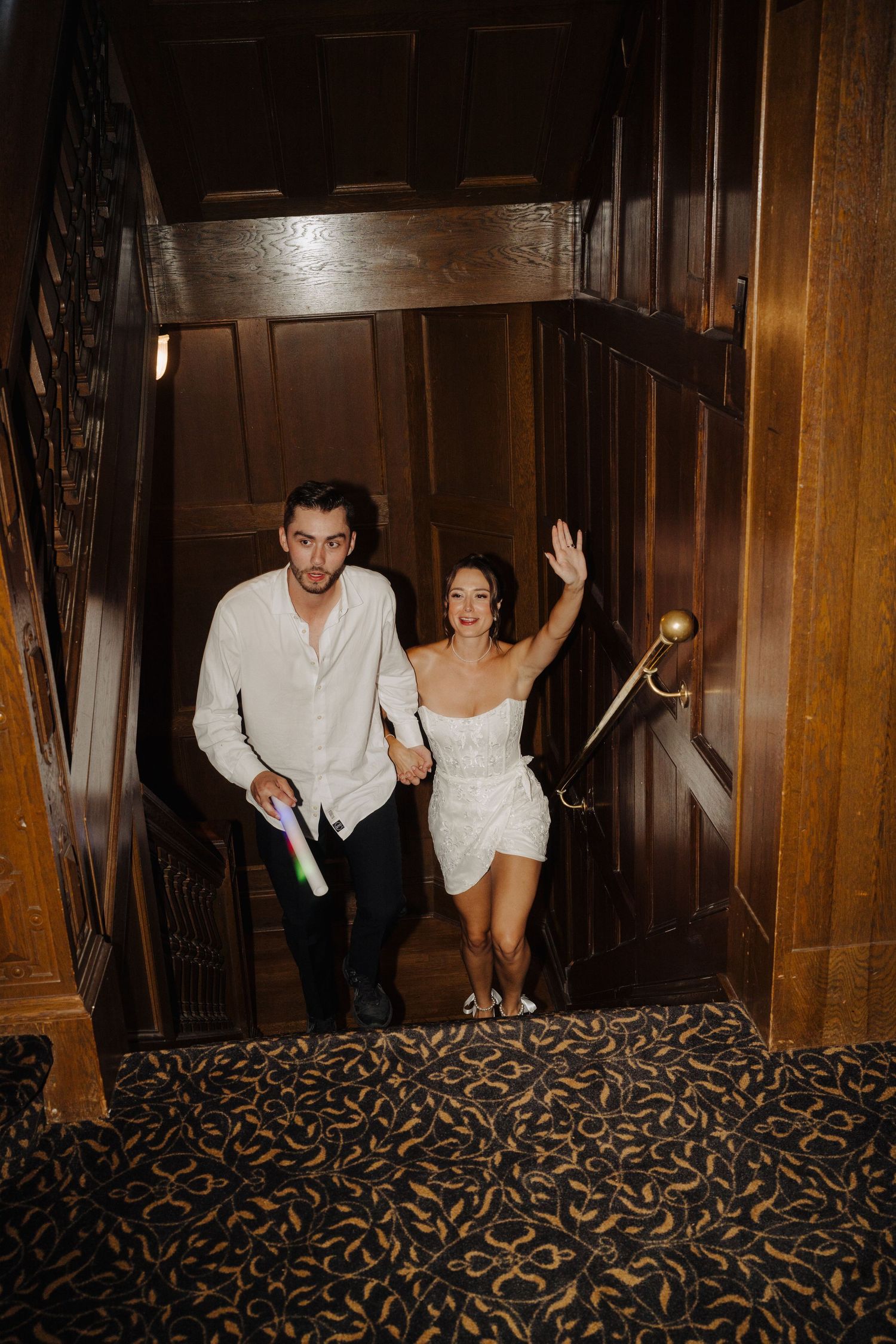 Dancing sequence in wood-paneled hallway with patterned carpet.