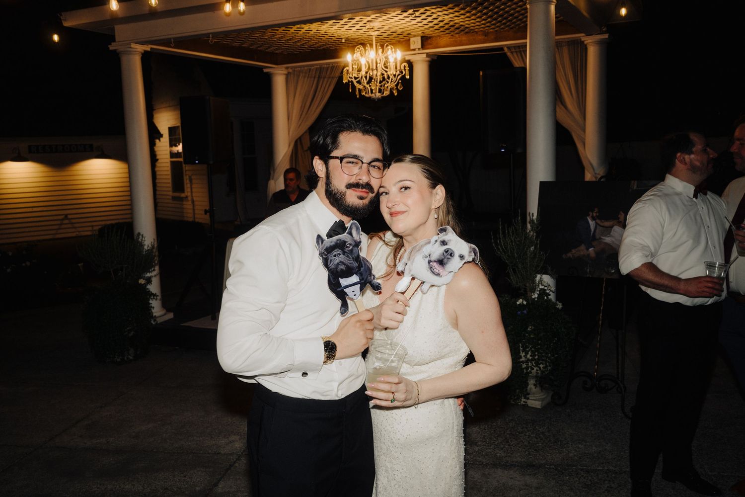 A wedding celebration at night with warm lighting and a chandelier overhead.
