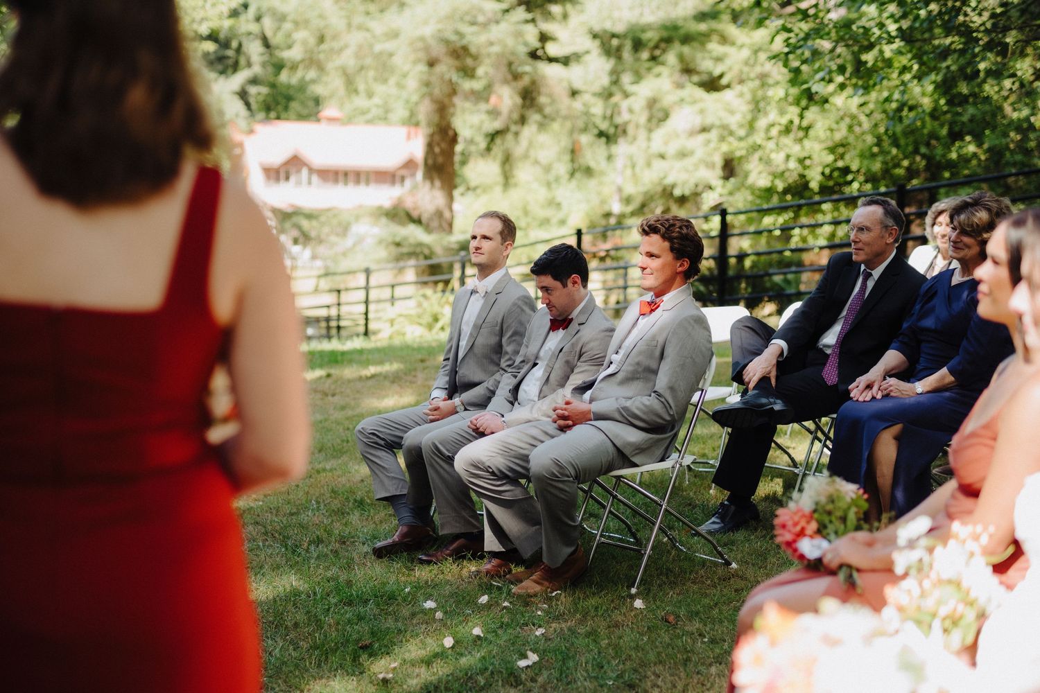Wedding guests and wedding party seated during an outdoor forest ceremony.