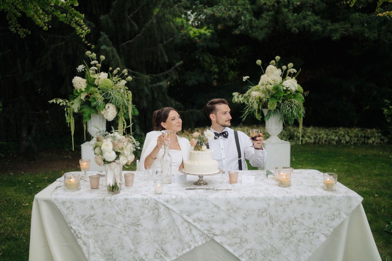 Elegant wedding reception table decorated with white linens and floral centerpieces.
