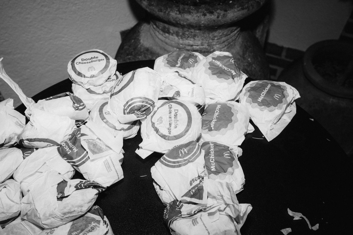 Black and white detail shot of empty plates and table settings at a wedding reception.