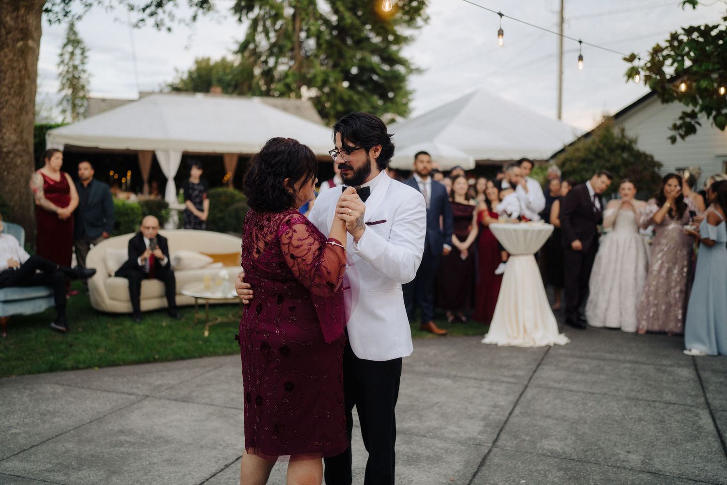 A couple sharing a dance moment at an outdoor wedding reception.