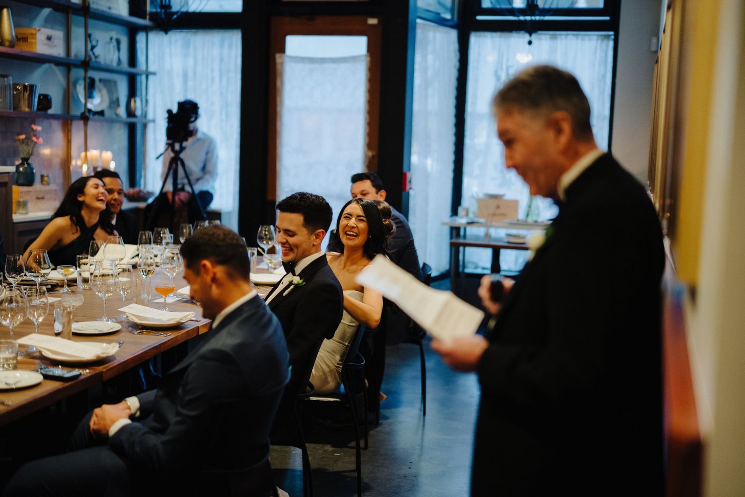 Wedding guests enjoy a reception dinner in an intimate restaurant setting.