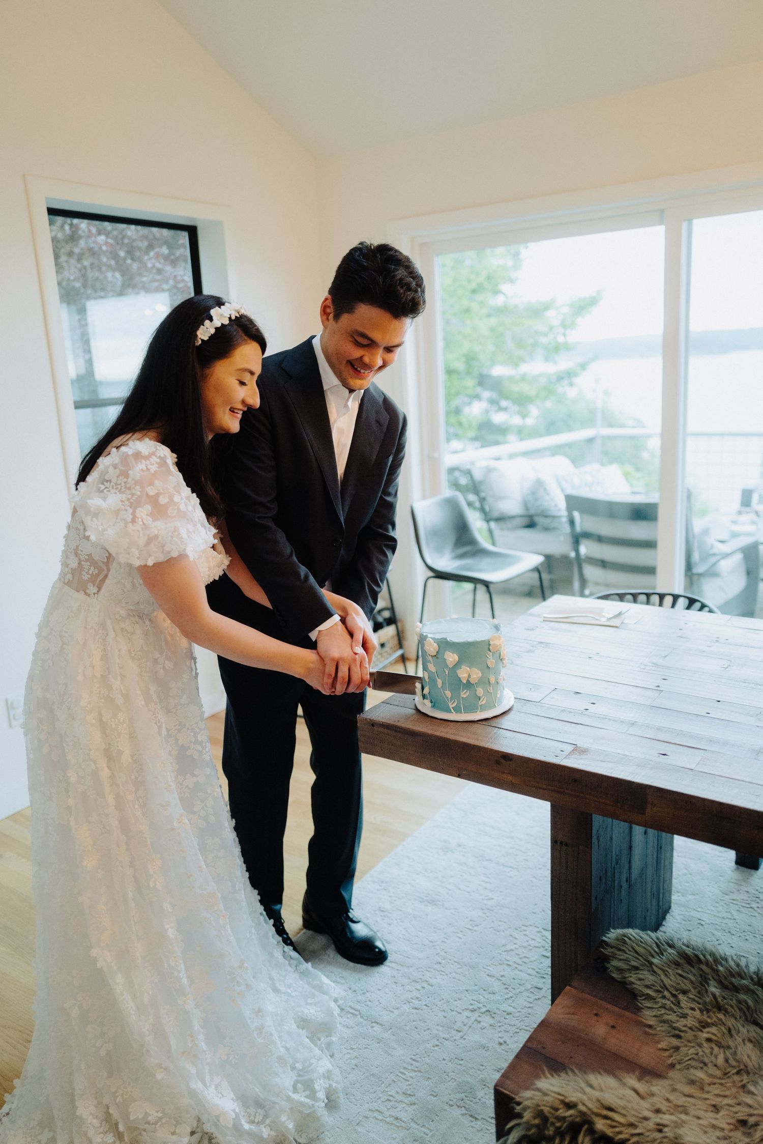 A couple sharing a moment at a rustic wooden table in a bright, modern space.