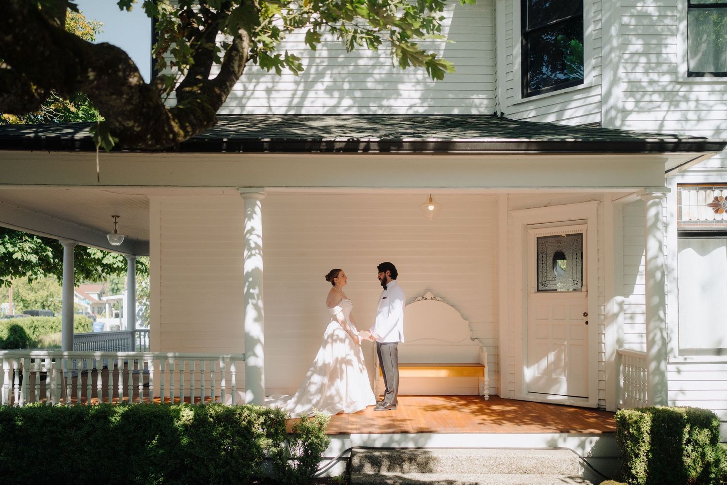 An outdoor wedding venue setup with white chairs and natural greenery.