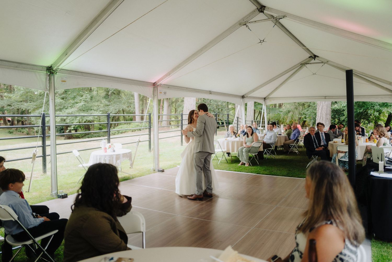Wide view of a tented wedding reception space with dance floor.