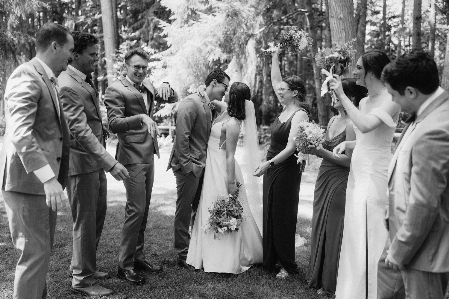 Wedding party and guests gathered outdoors for celebration photos.