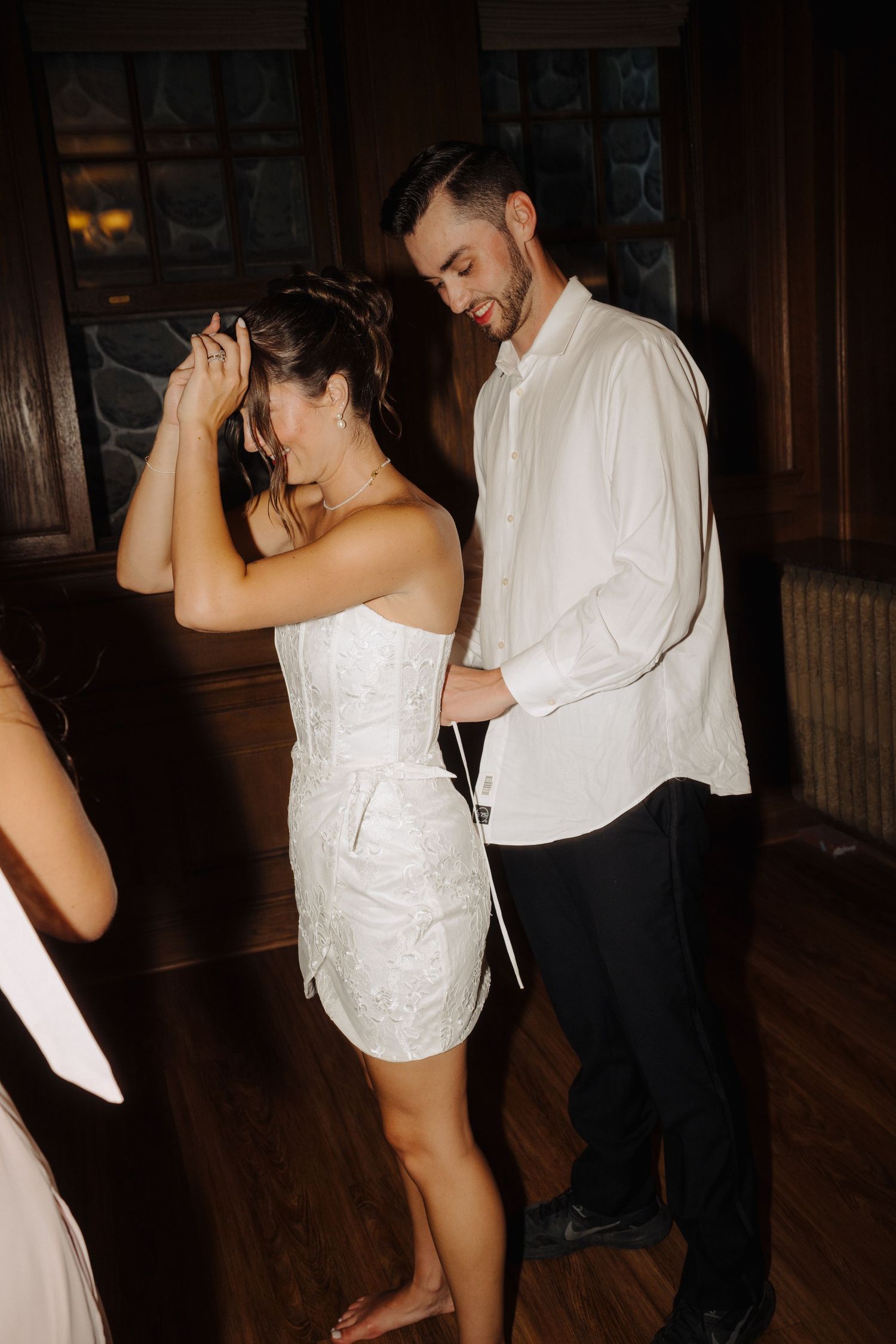 Couples dancing together in a dimly lit room during a wedding reception.