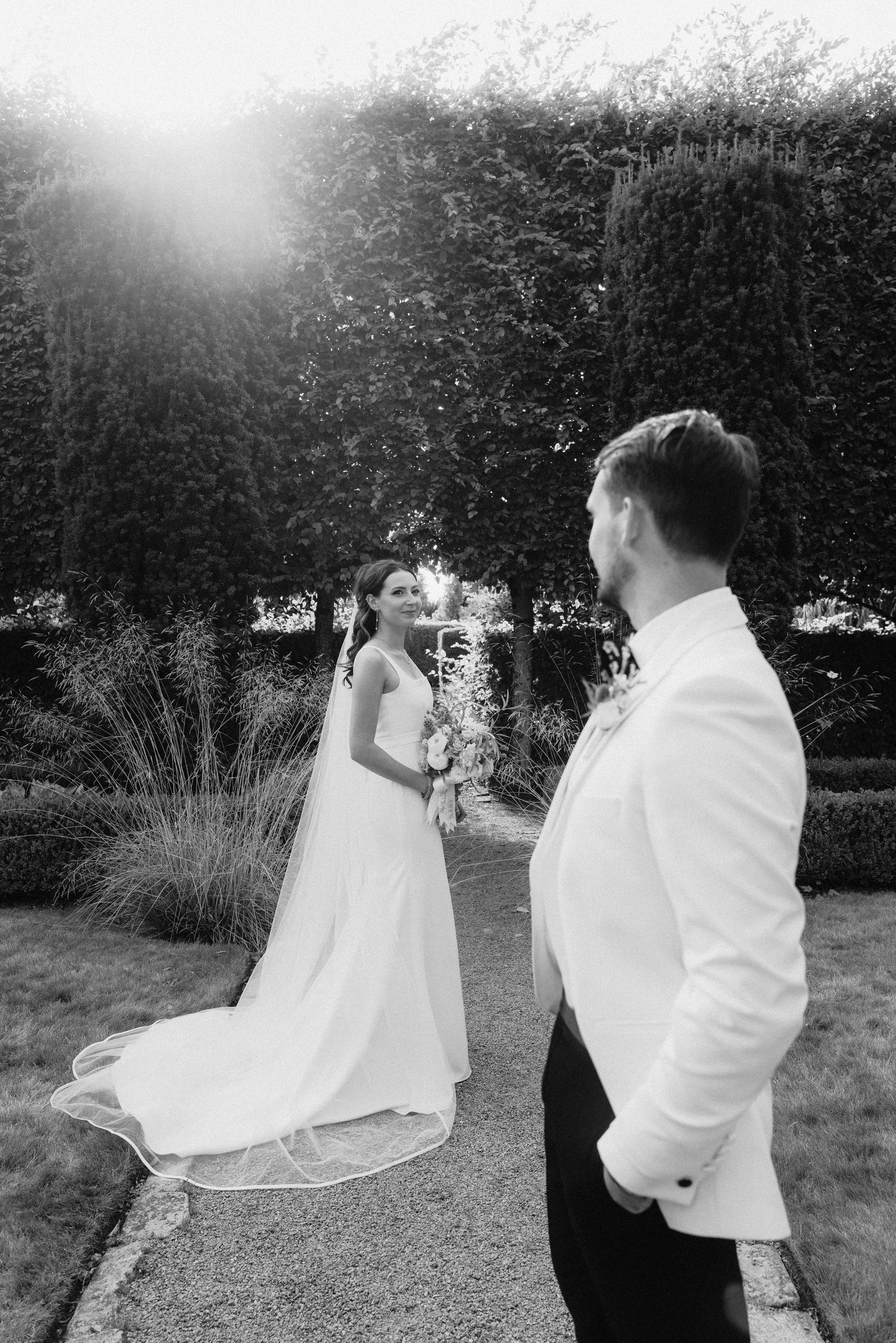 Black and white photos capture a romantic dance sequence between newlyweds in a garden setting.