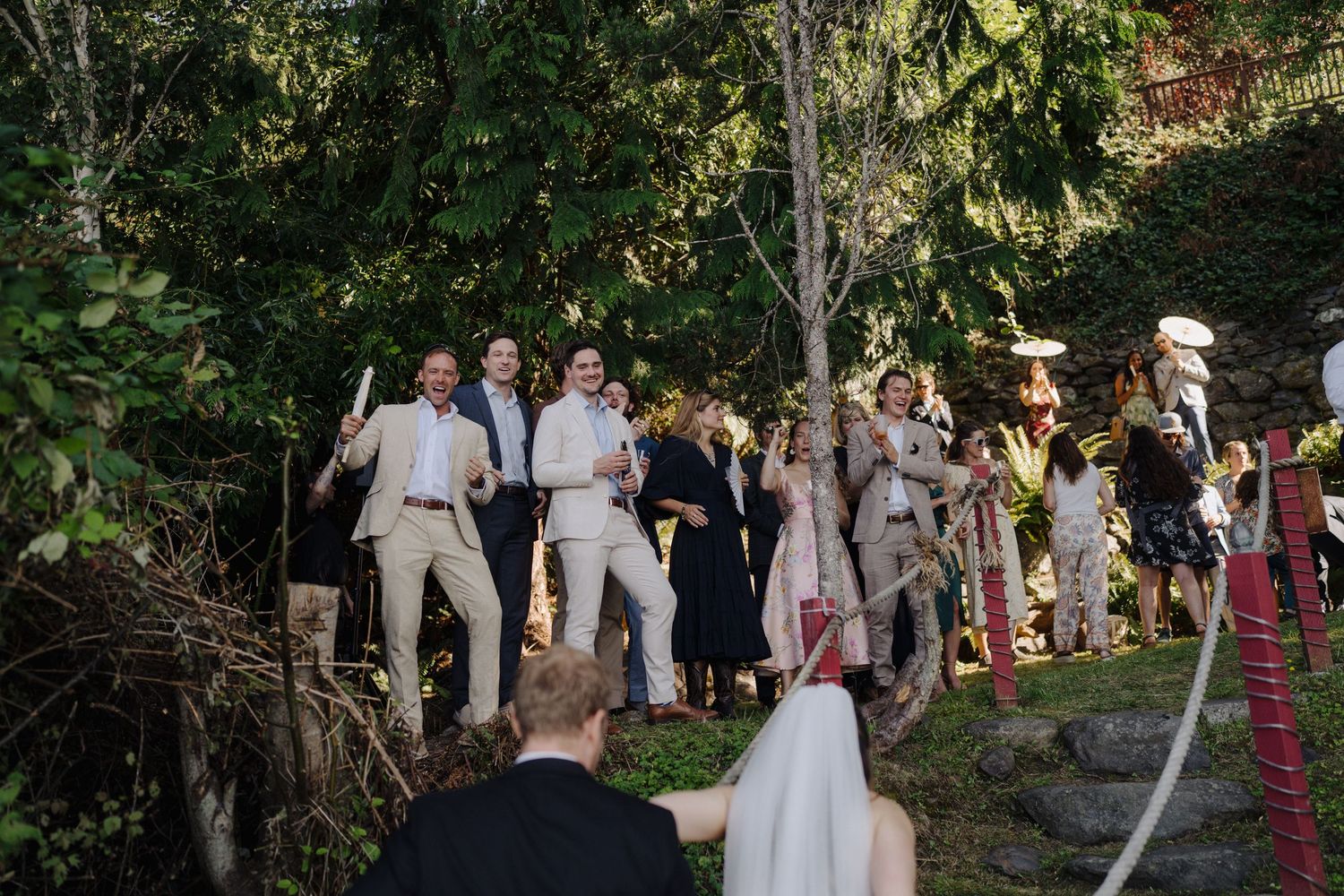 Wedding party gathers outdoors for a celebration in a natural setting.