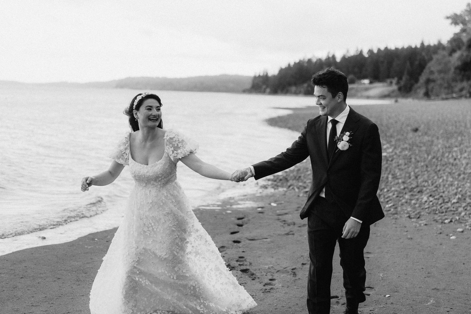A joyful couple shares a romantic moment while walking along a scenic beach shoreline.