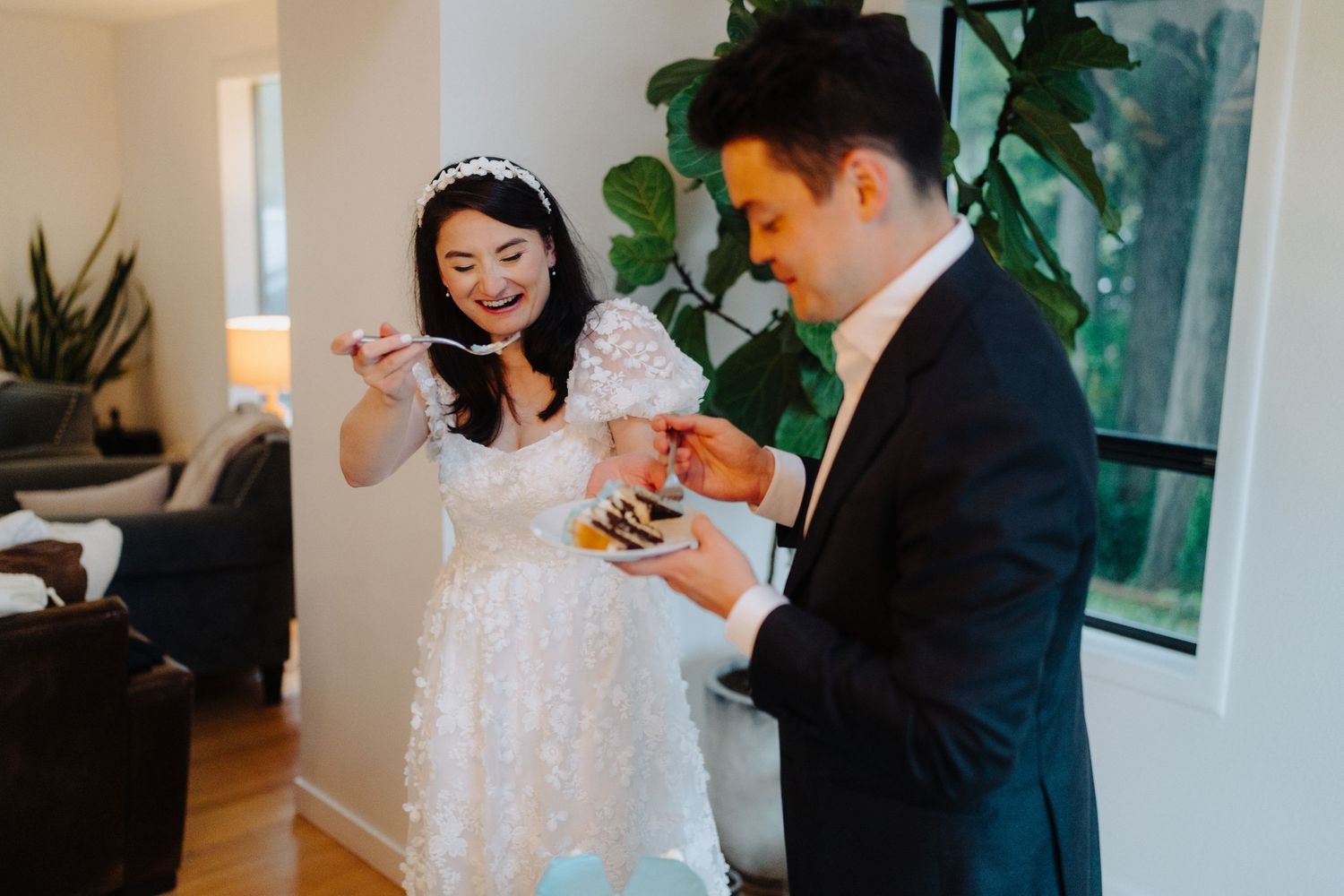 A couple sharing a joyful moment during their wedding celebration in a bright indoor setting.