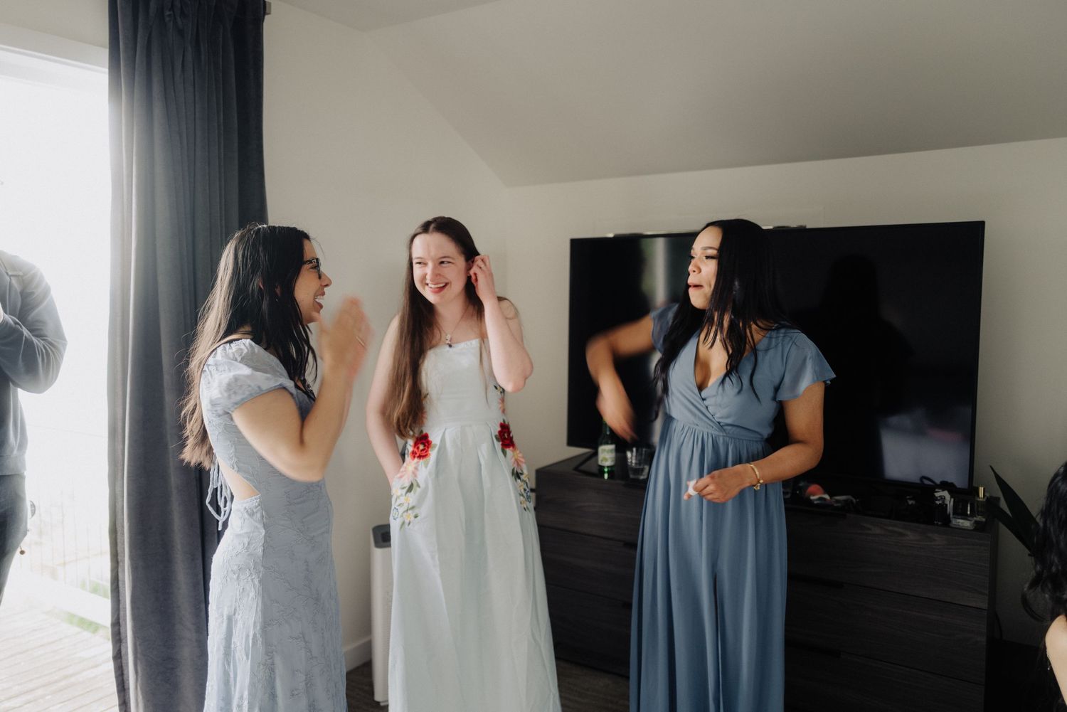 A group of people in blue and white dresses stand together during a wedding celebration.