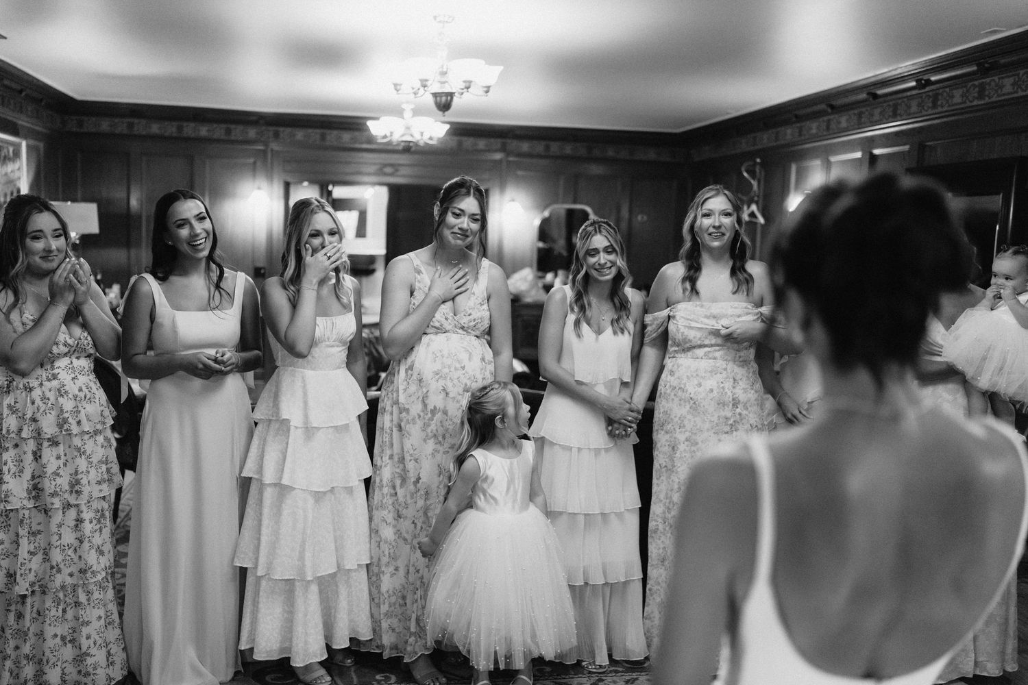 A series of black and white wedding photographs showing bridesmaids in floral dresses arranged in a row.