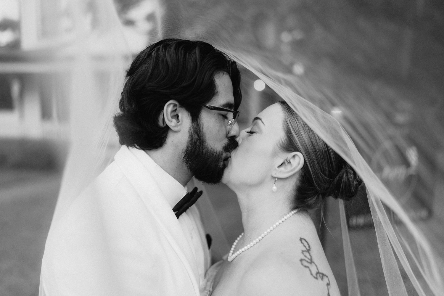 Black and white romantic wedding moment captured in an intimate outdoor setting.