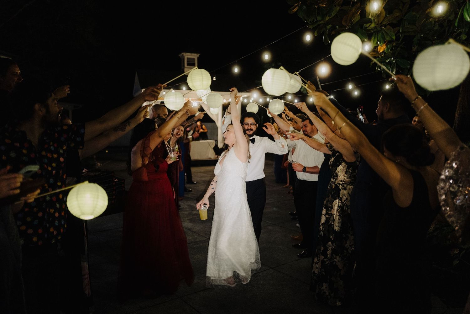 Wedding reception dance floor with string lights and lanterns creating a romantic evening atmosphere.