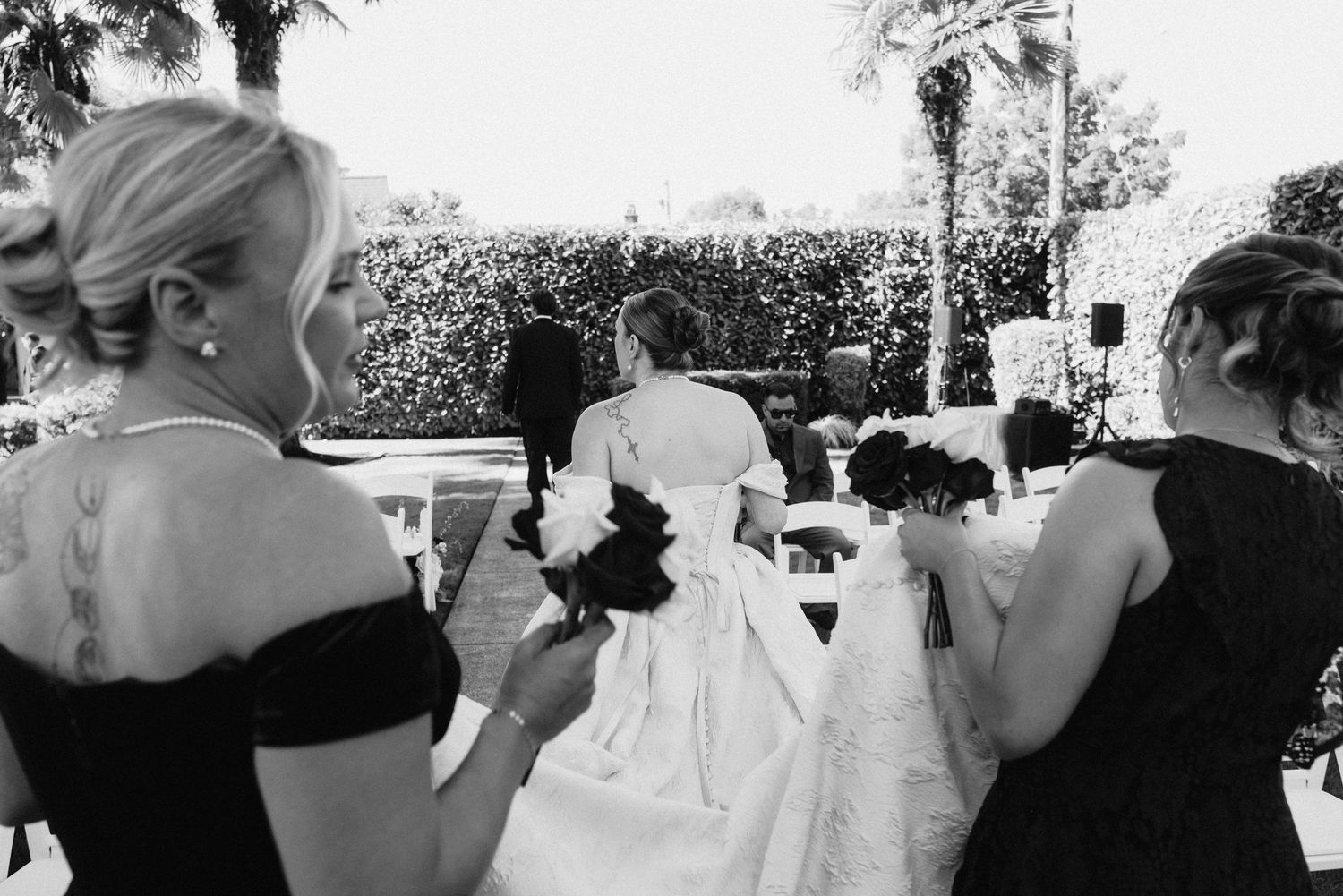 Wedding guests watching the ceremony in a landscaped garden setting.