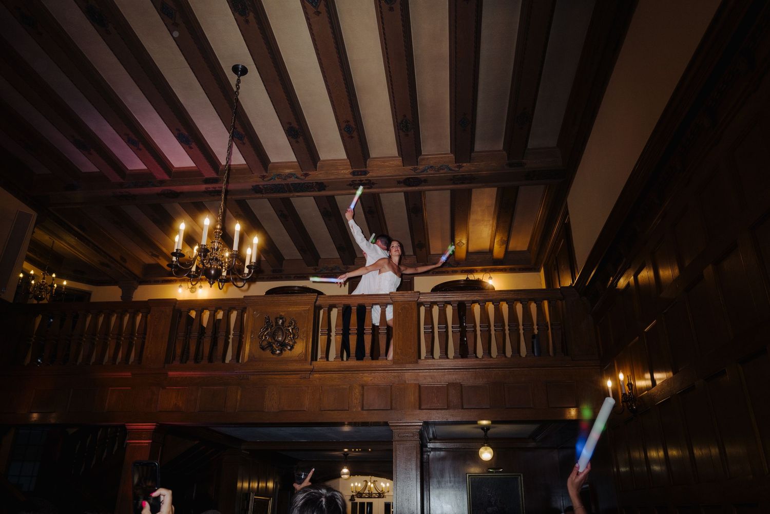 Elegant wedding reception venue with exposed wooden beams and warm lighting.