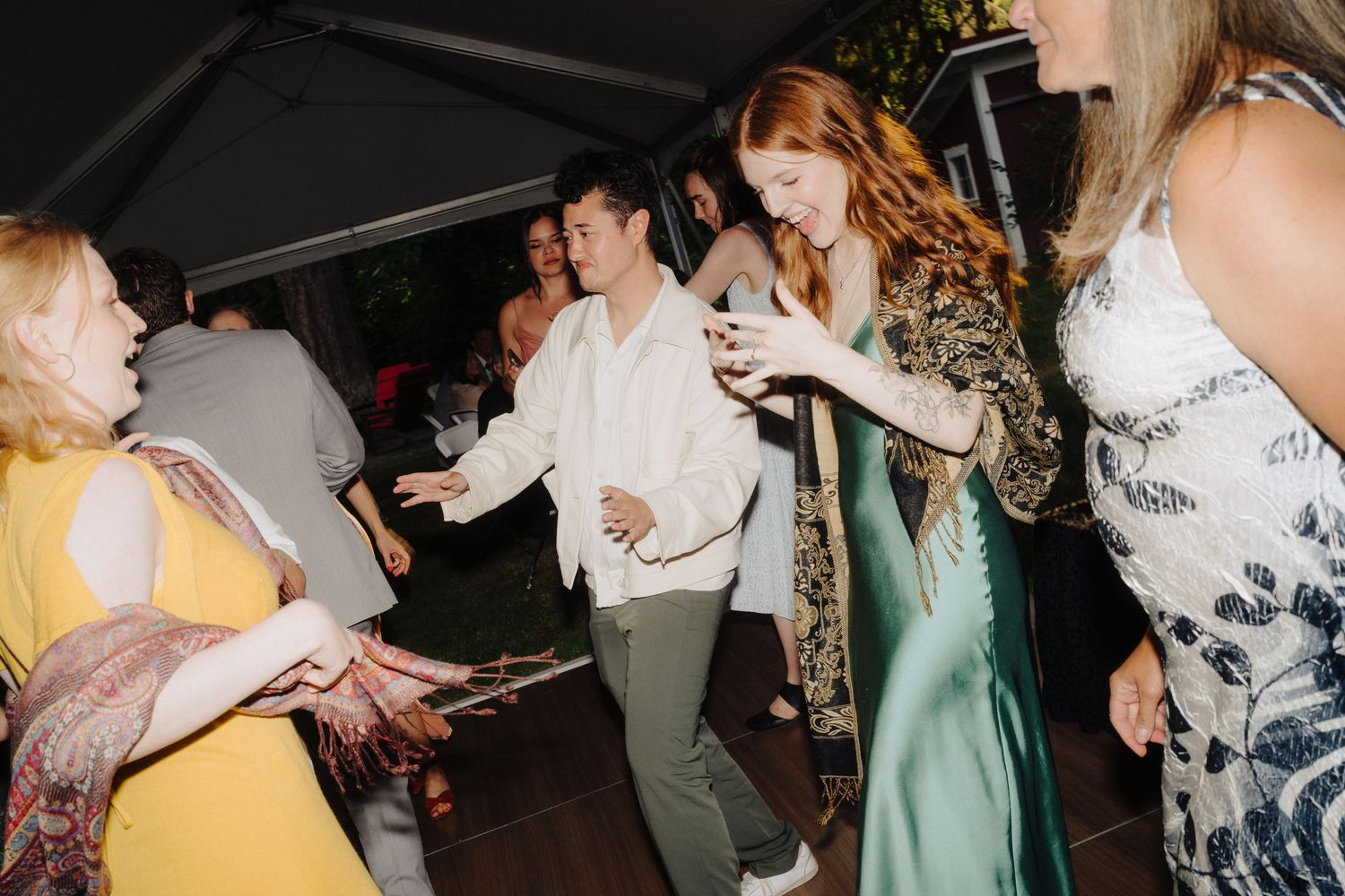 Wedding guests dancing and celebrating together at an evening reception party.