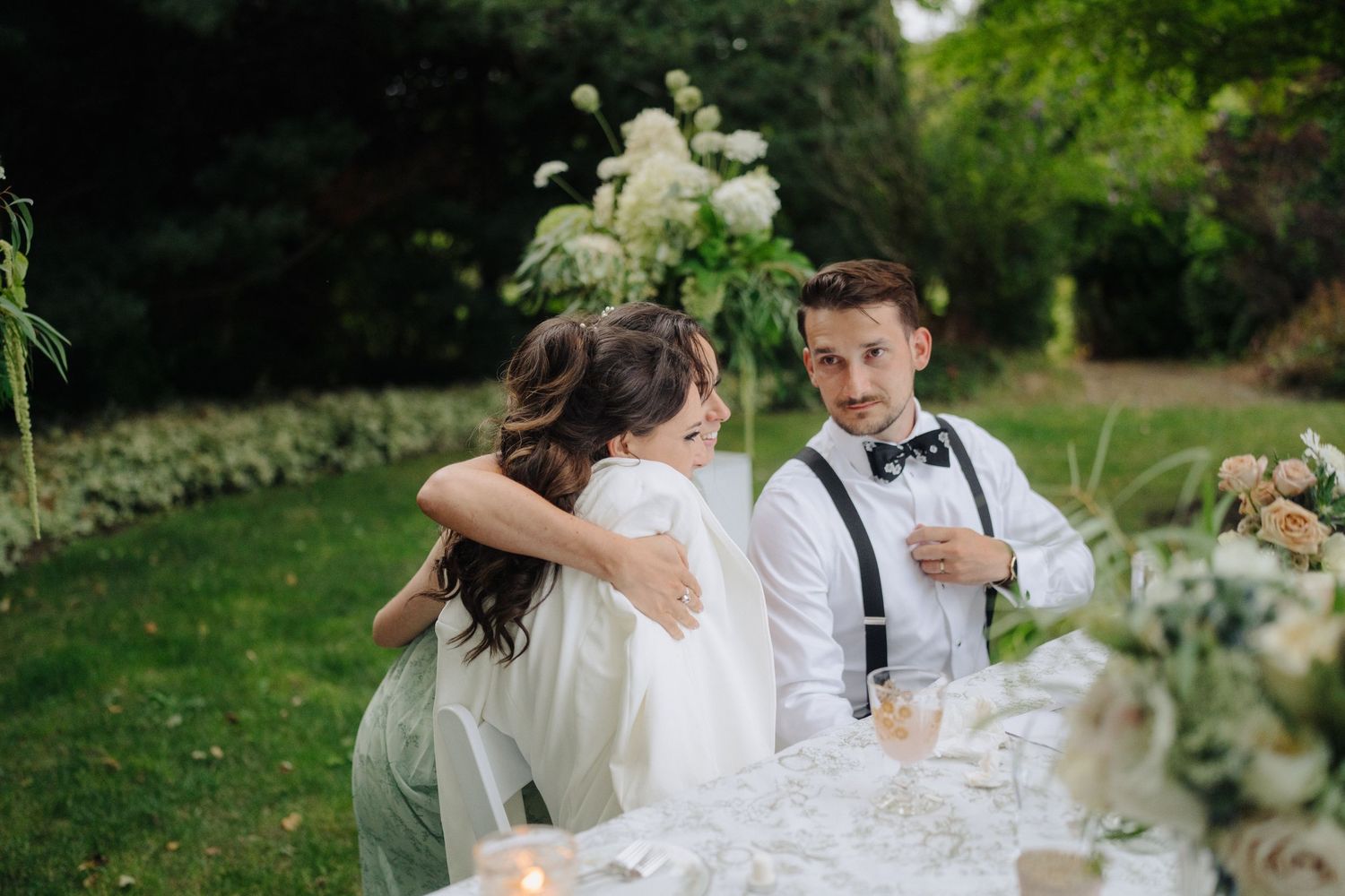 Garden wedding reception with white floral arrangements and natural greenery decorations.