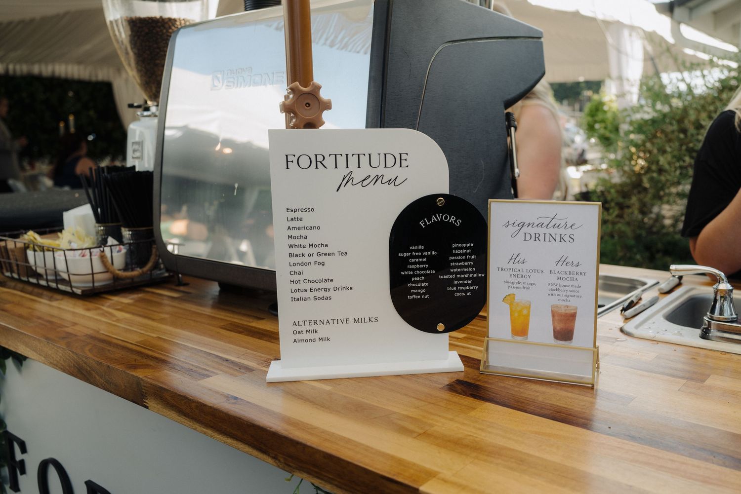 Fortitude bar menu and drink list displayed on wooden counter at event.